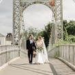 Bride Wearing Modern Wedding Dress Called Marilyn By Sottero And Midgley Walking With Groom On A Bridge