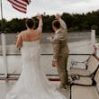 Bride wearing Tuscany Marie wedding dress by Maggie Sottero waving with her husband