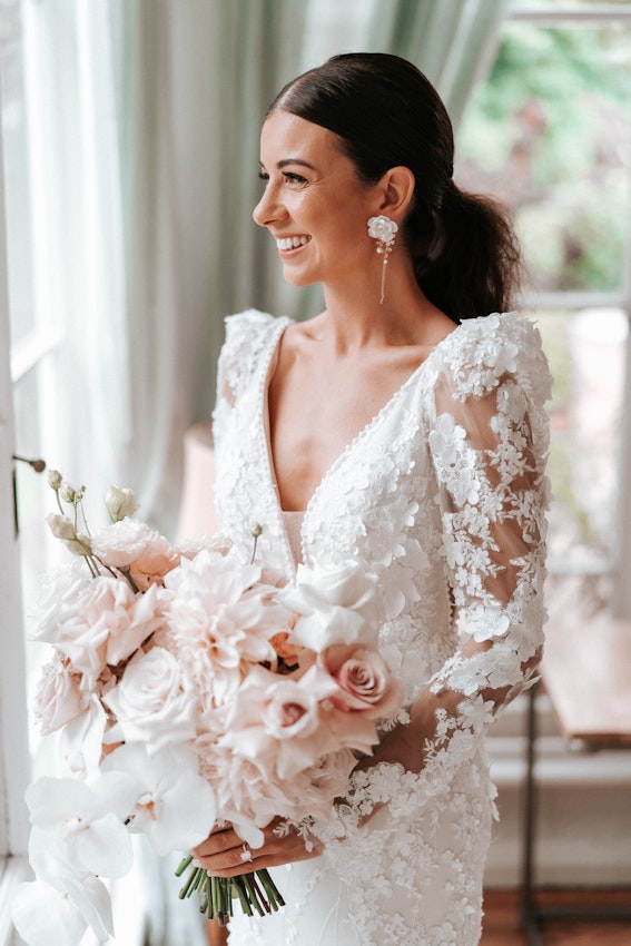 Real Bride wearing puff sleeve wedding dress with 3D floral details called Cruz by Sottero and Midgley..