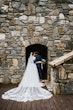 Bride Wearing Shimmery Princess Bridal Gown Called Tiffany By Maggie Sottero Kisses Groom With Veil