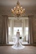 Bride Wearing Simple Off-the-shoulder Wedding Dress Called Josie By Rebecca Ingram In A Bathroom