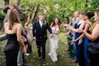 Bride wearing Tuscany Lynette walking with her husband surrounded by their guests