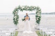 Bride Wearing Boho Sheath Wedding Dress Called Marisol By Rebecca Ingram With Groom On The Beach