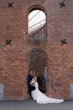 Bride Wearing Lace Crepe Bridal Dress Called Bracken By Sottero And Midgley With Groom Under A Brick Archway