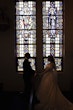 Bride wearing Ulanda wedding dress by Maggie Sottero with groom in front of stained glass window