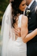 Bride with groom wearing satin sheath wedding dress.