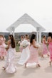 Bride wearing Mitchell by Maggie Sottero walking with her bridesmaids