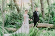 Bride Wearing Off-The-Shoulder A-Line Wedding Dress Called Coral By Rebecca Ingram With Groom In A Forest