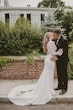 Bride and groom kissing with the ivory bouquet rested on her train.