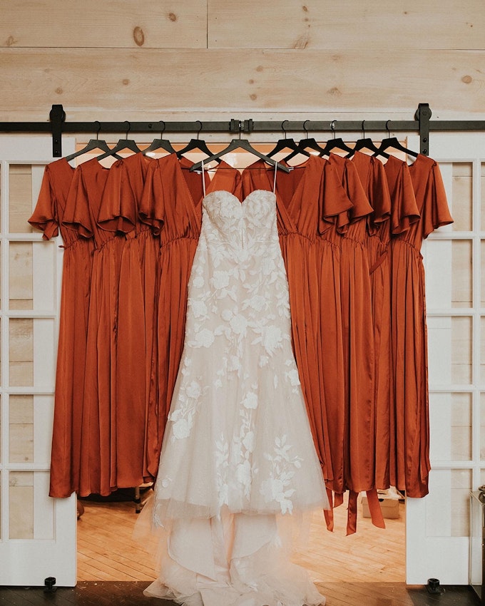 Wedding Dress Called Hattie by Rebecca Ingram Hanging with Bridesmaid Dresses