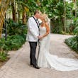 Bride Wearing Lace Mermaid Wedding Dress Called Bronson By Sottero And Midgley Kissing Groom In A Garden