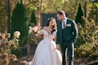 Bride Wearing Floral Ballgown Wedding Dress Called Derrick Marie Holding Hands With Groom