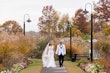 Bride Wearing Sexy Lace Wedding Dress Called Lennon By Maggie Sottero Holding Hands With Groom In A Garden