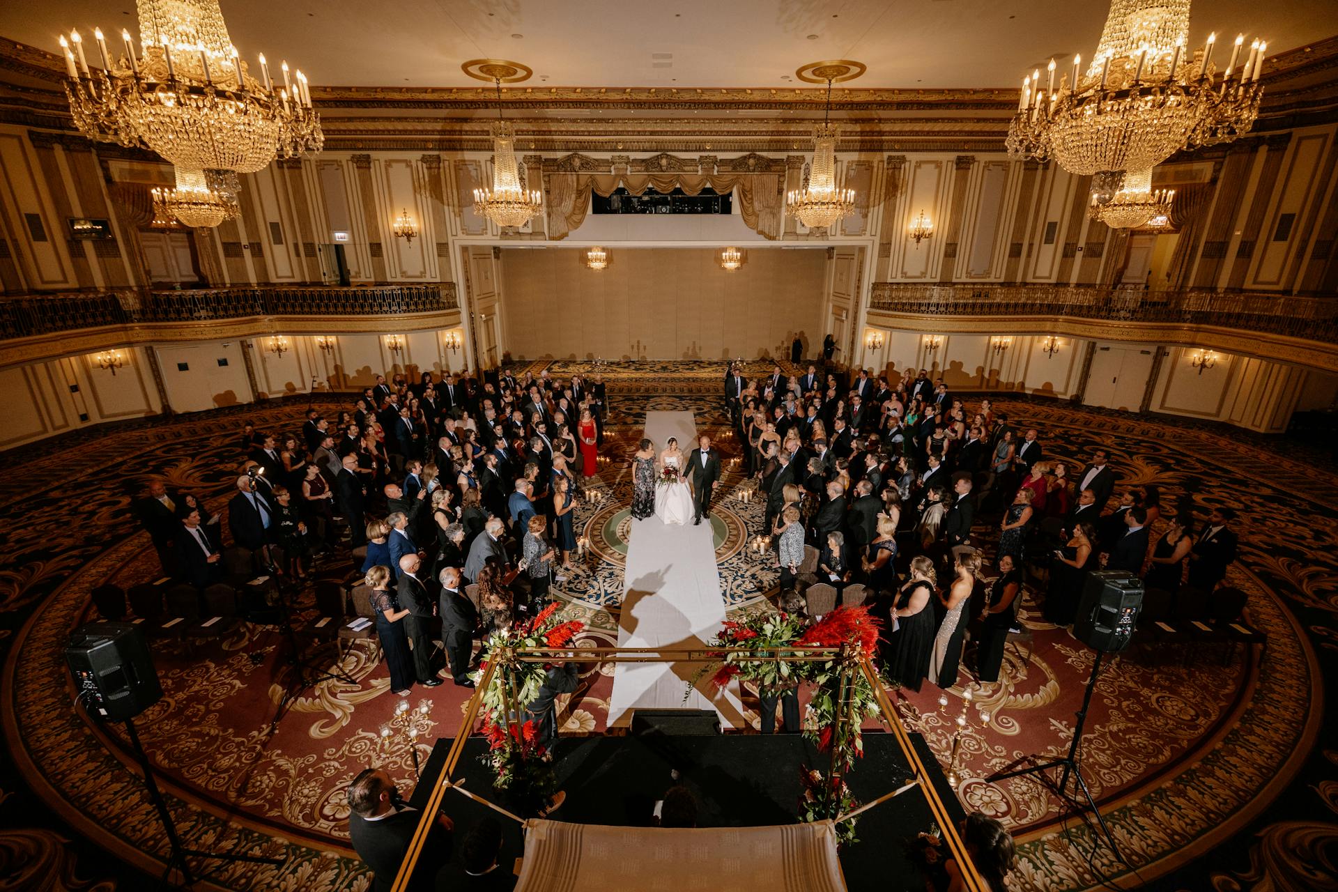 Wedding In A Grand Ballroom With Chandeliers And Lots Of Guests