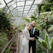 Bride wearing Bethany wedding dress by Rebecca Ingram with her husband inside a greenhouse