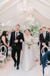 Bride Wearing Off-The-Shoulder A-Line Wedding Dress Called Coral By Rebecca Ingram Walking Down The Aisle