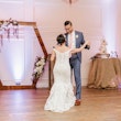 Groom and Bride Dancing Wearing Beaded Lace Off-the-Shoulder Wedding Gown Called Elias by Sottero and Midgley