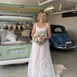Bride wearing Mindel wedding dress by Maggie Sottero next to car