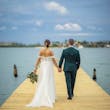 Bride And Groom Walking Together. Bride Wearing Tulle A-Line Off The Shoulder Wedding Dress With 3D Floral Details Called Mirra By Maggie Sottero